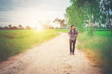 Obraz premium Young hipster man with backpack on his shoulder walking down cou