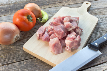 Chopped pork meat for goulash on wooden board
