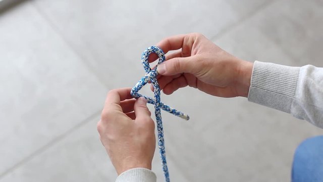 Tie eight knot on a rope on gray background
