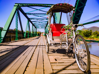 Fototapeta na wymiar Tri-cycling on the bridge in Pai, Travel place in north Thailand