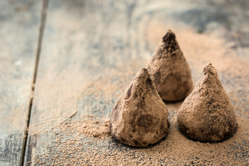 Homemade chocolate truffles on wooden table

