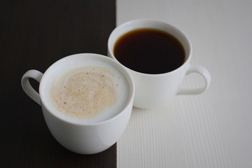 Two cups of black and white coffee