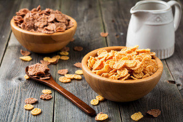 Cornflakes for breakfast in a bamboo plate on old wooden background. Selective focus.