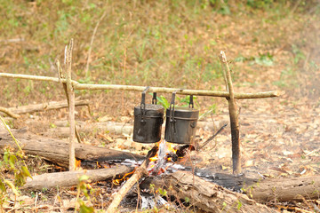 Cooking pot in campfire, Camping in forest, Preparing food on campfire