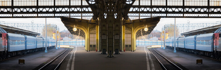 Concept of time, changes, travel. Deserted morning railway station. Wide panoramic scenic composition.