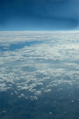 Couche de nuages vue à travers un hublot passager d'un avion de ligne en vol