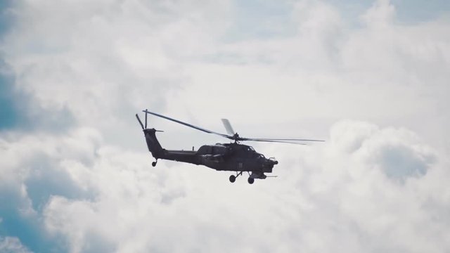 Attack helicopter "Night Hunter" Mi-28 performs aerobatics on a background of blue sky and clouds. Includes audio. Contains audio