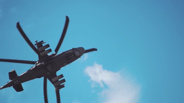 Reconnaissance and attack helicopter of the new generation Ka-52 "Alligator" flying on a background of blue sky and clouds. Includes audio. Contains audio