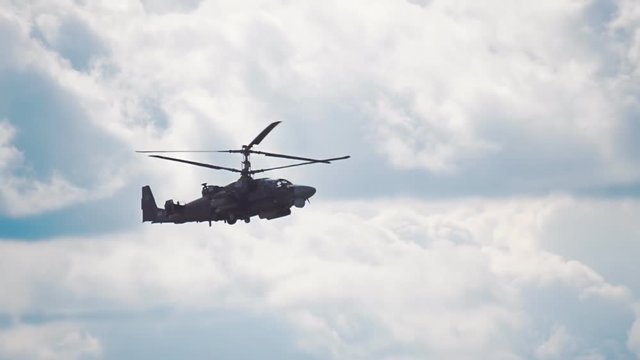 Reconnaissance and attack helicopter of the new generation Ka-52 "Alligator" flying on a background of blue sky and clouds. Includes audio. Contains audio