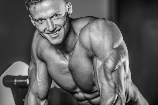 Handsome muscular bodybuilder man doing exercises in gym © antondotsenko