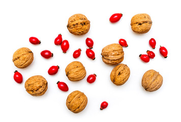 Walnuts and rose hips isolated on white background