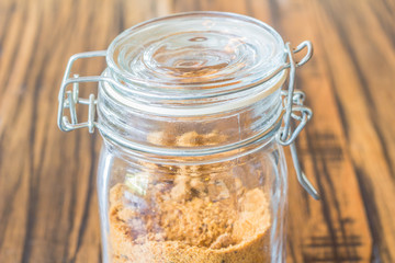 Glass jar of sugar on wooden table