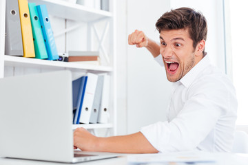 Naklejka na ściany i meble Stressed angry businessman hitting laptop with fist