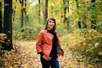 girl walking in the autumn yellow wood, maple grove