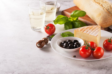 Italian appetizers, view from above - bread ciabatta, olives, tomatoes, cheese, pepper, fresh basil...