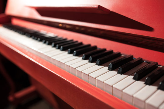closeup shot of vintage red classical piano;