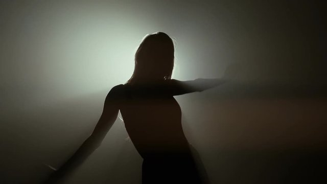 Professional young ballet dancer posing in studio lights