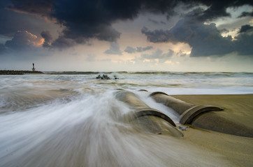 beautiful nature, soft waves hitting concrete drainage pipe on t