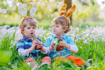 Two little kids playing with Easter chocolate bunny