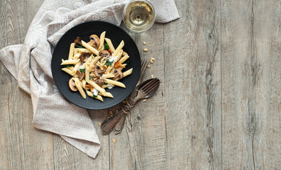 Pasta with mushrooms on rustic wooden table