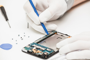 technician repairing broken mobile phone