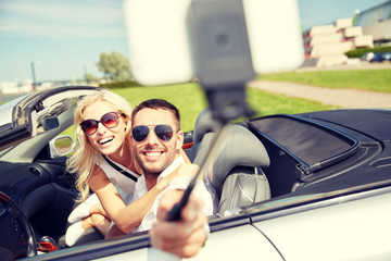 happy couple in car taking selfie with smartphone