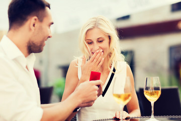 happy couple with engagement ring and wine at cafe