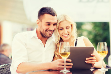 happy couple with tablet pc at restaurant lounge