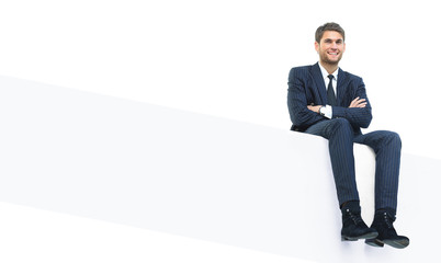 handsome young business man sitting on a white top © ASDF