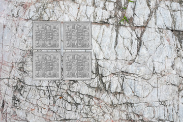 Grid of square glass block on stone wall