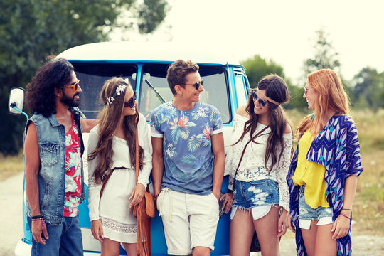 smiling young hippie friends over minivan car