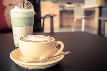 yellow cup of coffee on cafe table