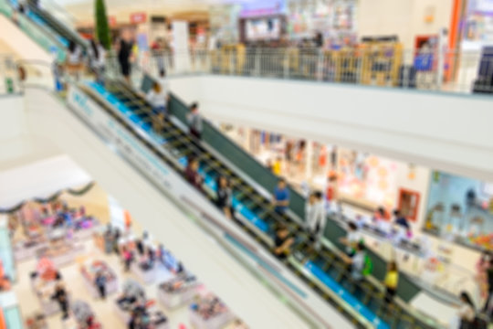 Blurred escalator in in department store with people crowded