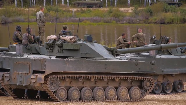 Armored military BMP and soldiers on the board, successful cross the river by swimming. Quadrocopter shooting 