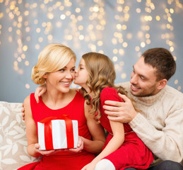 happy family with christmas gift kissing