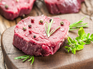 Piece of beef tenderloin on the wooden cutting board.