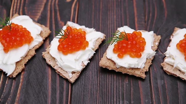 crackers with cream cheese and red caviar close-up
