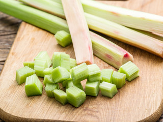 Edible rhubarb stalks on the wooden table.