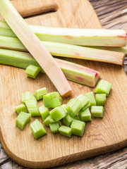 Edible rhubarb stalks on the wooden table.