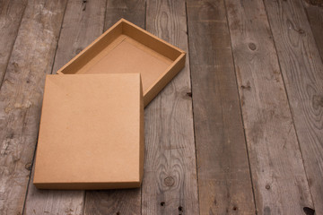 Opened cardboard box on wooden background