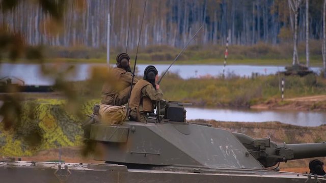 Armored military BMP and soldiers on the board, successful cross the river by swimming. Quadrocopter shooting 