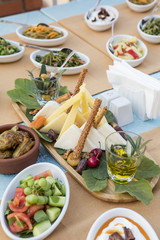 Cheese plate with variety of appetizers on table
