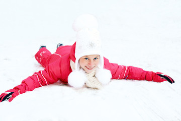 Cute little girl riding on snow slides in winter time