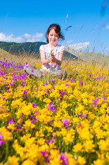 Fototapeta premium Girl sitting in a field of wild flowers