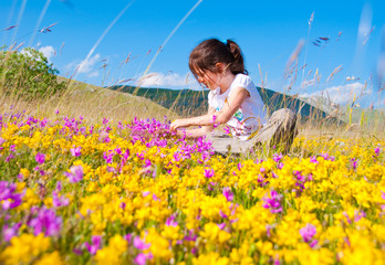 Girl sitting in a field of wild flowers