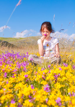 Girl sitting in a field of wild flowers