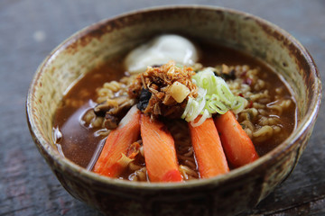 Noodles with egg spicy soup on wood background