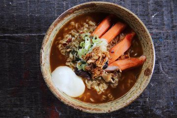 Noodles with egg spicy soup on wood background