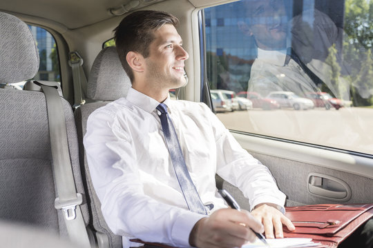 Businessman sitting on a backseat in a taxi