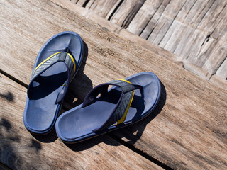 blue flip flops on the brown wooden floor with natural day light